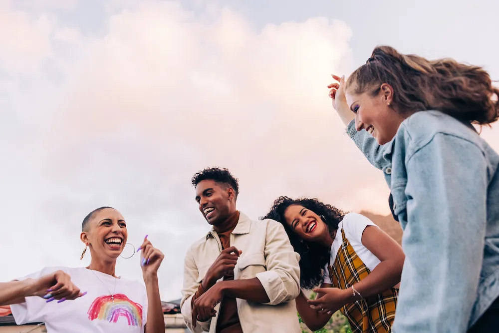 Four young adults laughing together