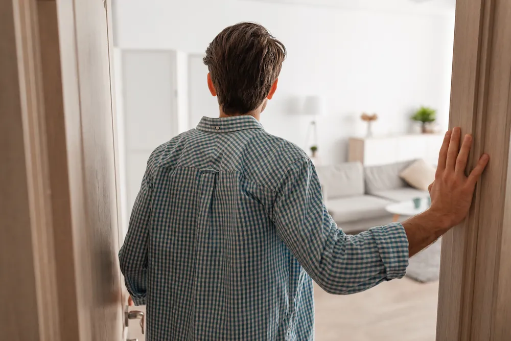 Young man walking into his apartment